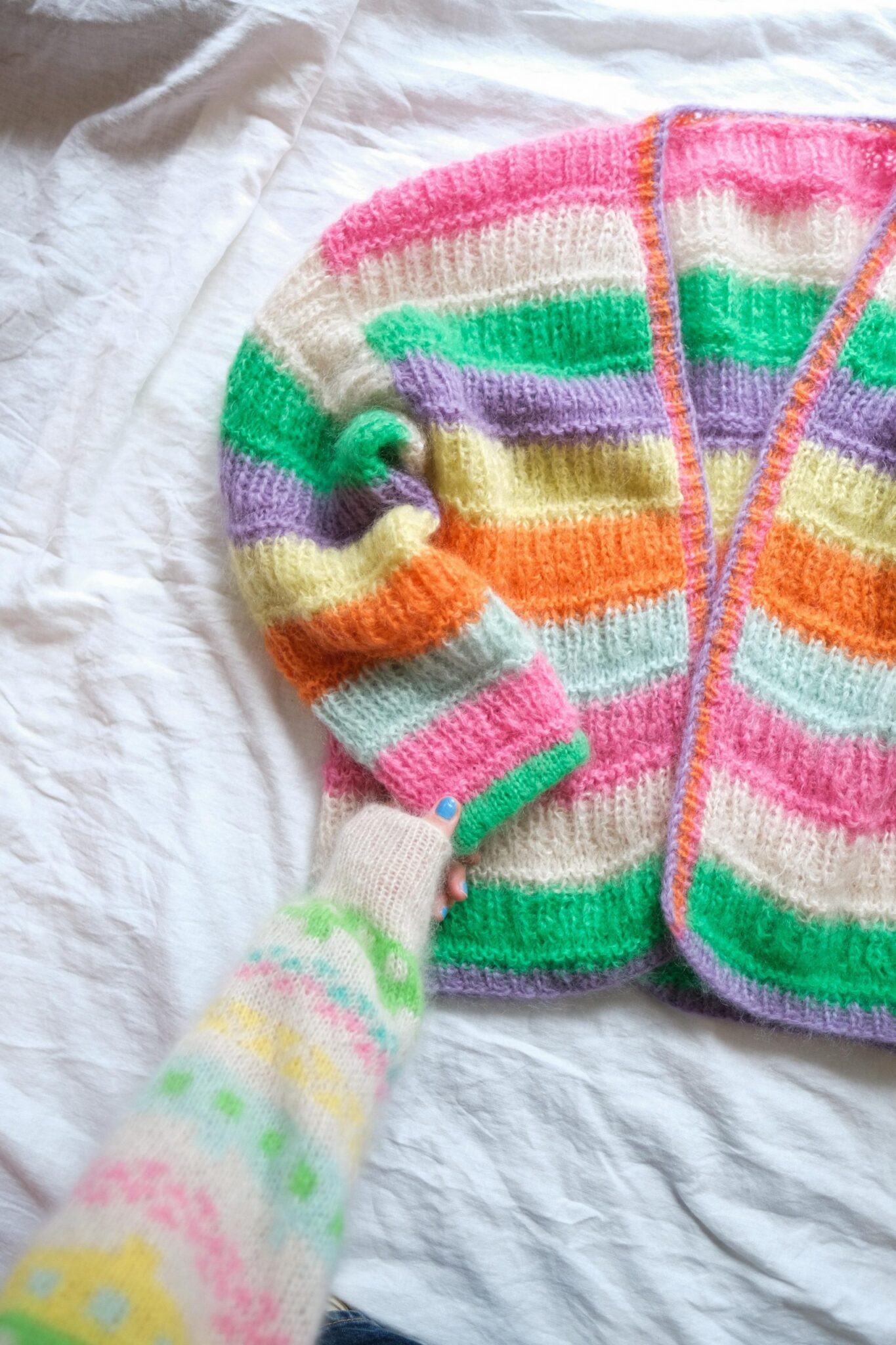 - HipKnitShop PEACHES JACKET STRIKKEOPPSKRIFT Strikkeoppskrift myk og deilig jakke. Jakken strikkes ovenfra og ned, noe som gjør det enklere å tilpasse lengden på ermer og bol underveis. Først strikkes for- og bakstykket hver for seg, frem og tilbake. Når ermeåpningen er ferdig settes stykkene sammen på en pinne og strikkes videre nedover bol, frem og tilbake. Ermene strikkes ovenfra og ned, ved å strikke opp masker i ermeåpning Jakken strikkes i Fluff Mohair. Fargene på bildet er Candy pop Pink, Latte lover, Jelly Bean Green, Lilac Breeze, Lemonade, Oh la la orange og Must have mine. Den avbildete jakken er i str M/L (modell er 169 cm høy og str S/M). Garnpakke med gratis oppskrift finner du her: Peaches jacket garnpakke STØRRELSE OG MÅL XS/S (M/L )XL/XXL Hel lengde: 57 (57) 65 cm Overvidde: 108 (122) 140 cm (før vask) Erme: 44 (44) 55 cm Plagget har en bevegelsesvidde/ «positive ease» på ca 15-25 cm. Mål overvidde og velg størrelse etter mål som er + 15-25 cm fra din egen overvidde (eller etter ønske). Mål g jerne overvidden på en jakke du har fra før av og liker passformen på. Etter damp / skylling vil genser gå ut ca 5 cm i overvidde (og kan også strekkes litt i fasong om ønskelig). GARN Farge 1: 2 (2) 2 nøster Farge 2: 2 (2) 2 nøster Farge 3: 1 (1) 2 nøster Farge 4: 1 (1) 2 nøster Farge 5: 1 (1) 1 nøster Farge 6: 1 (1) 1 nøster Farge 7: 1 (1) 1 nøster Farge 8: 0 (0) 1 nøster Totalt 9 (10) 12 nøster. STRIKKEFASTHET 12 m x17 rader = 10 x 10 cm (før vask). Nivå: lett / middels Pinne 6 mm. 5 mm til kanter. Lang rundpinne (60 cm) og kort rundpinne + settpinner til ermer om du ikke strikker Magic Loop metoden. Gjerne flere pinner. Design av @humbleknit for HipKnitShop Når betalt- PDF mønster vil bli sendt via e-post automatisk – sørg for å sjekke spam/søppelpost hvis du ikke får det innen 5 min. Vennligst skriv ut eller lagre etter kjøp.